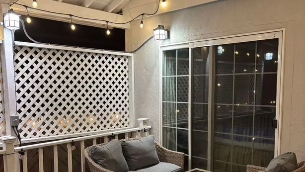 An outdoor patio area with wicker furniture, a glass table, and string lights. - 3B house in Redwood City Walk to Caltrain with AC Parking near Stanford 1Gbps (Redwood City)