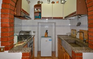 A compact kitchen with a refrigerator, stove, and sink. - 3 bedroom awesome apartment in Prata (Prata)