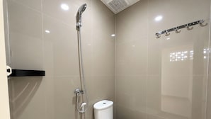 A modern bathroom with a toilet, a shower, and a towel rack.