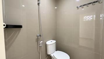 Een moderne badkamer met toilet, douche en een handdoekhouder.