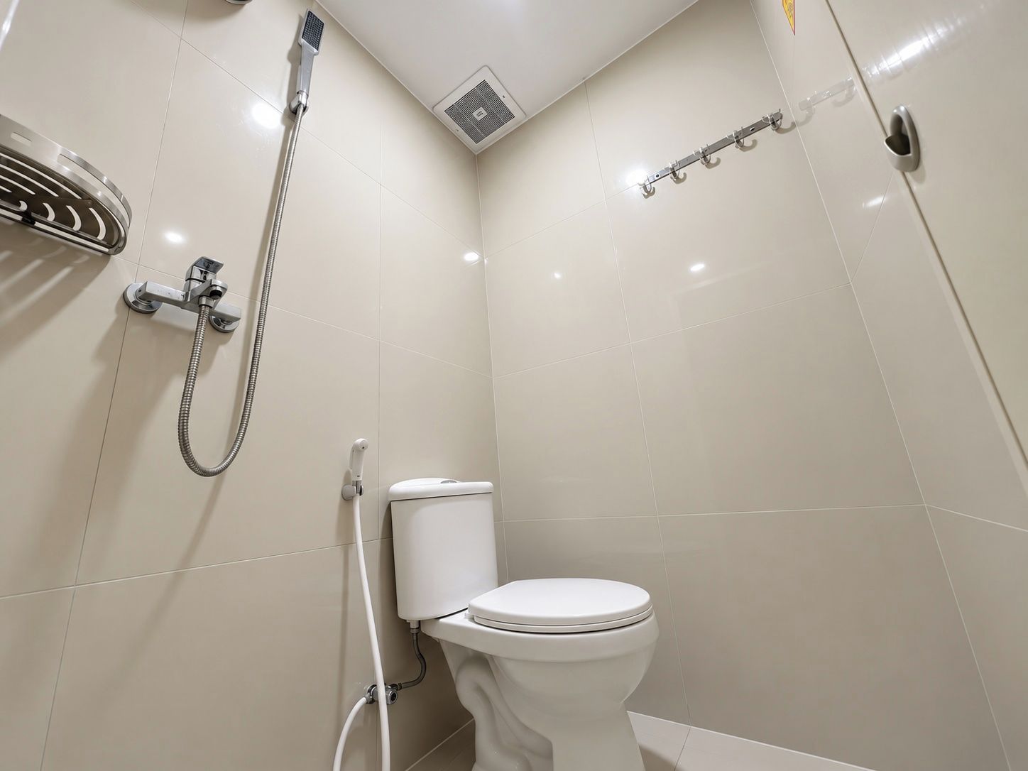 Ein kleines, modernes Badezimmer mit Toilette, Dusche und Handtuchhalter.