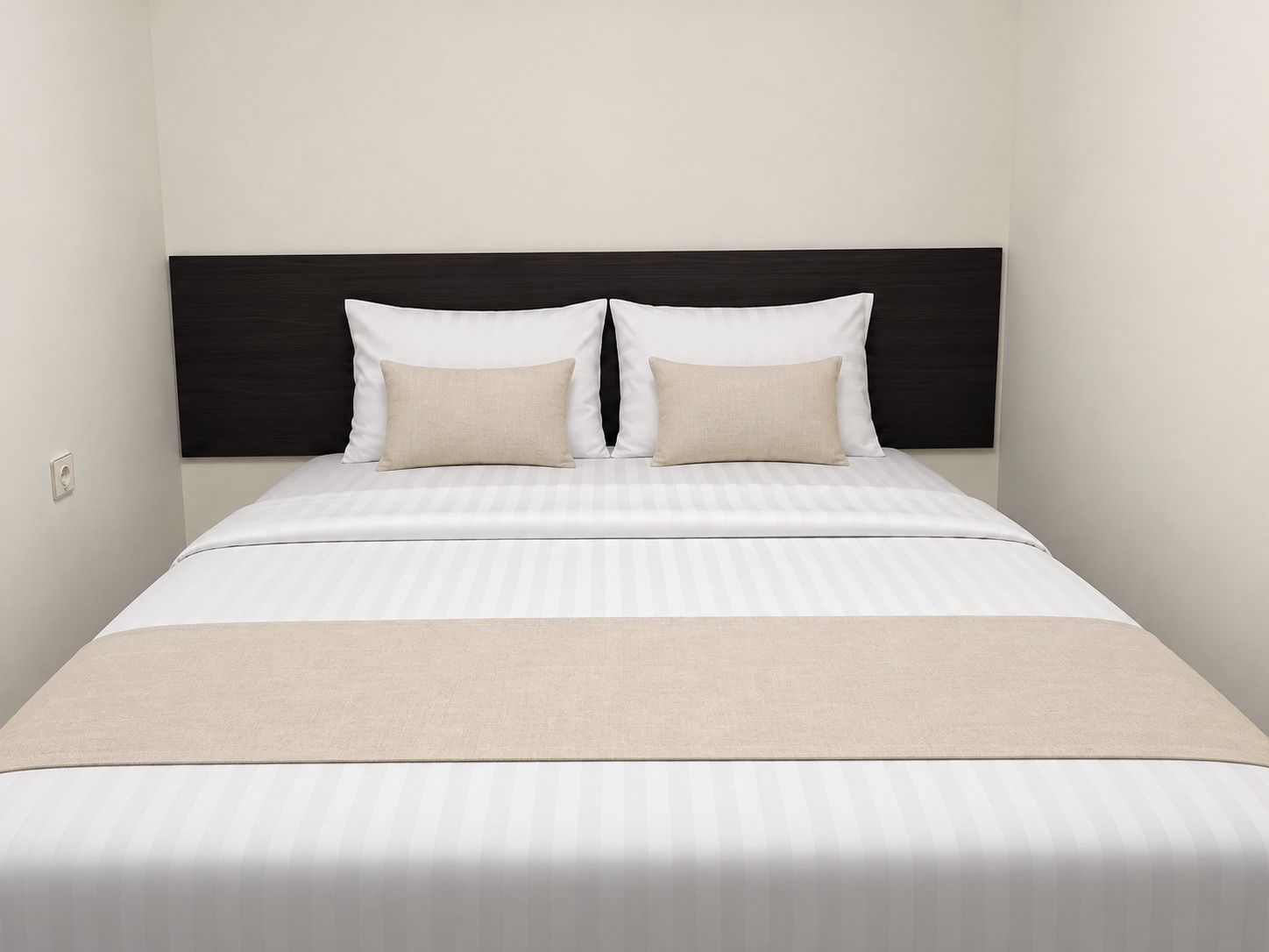 A bed with a dark headboard, two pillows, and a striped bedspread.