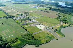 An aerial view of a rural area with fields, a parking lot, and a small body of water. - Two bedroom cottage Resort 62 (Haldimand)