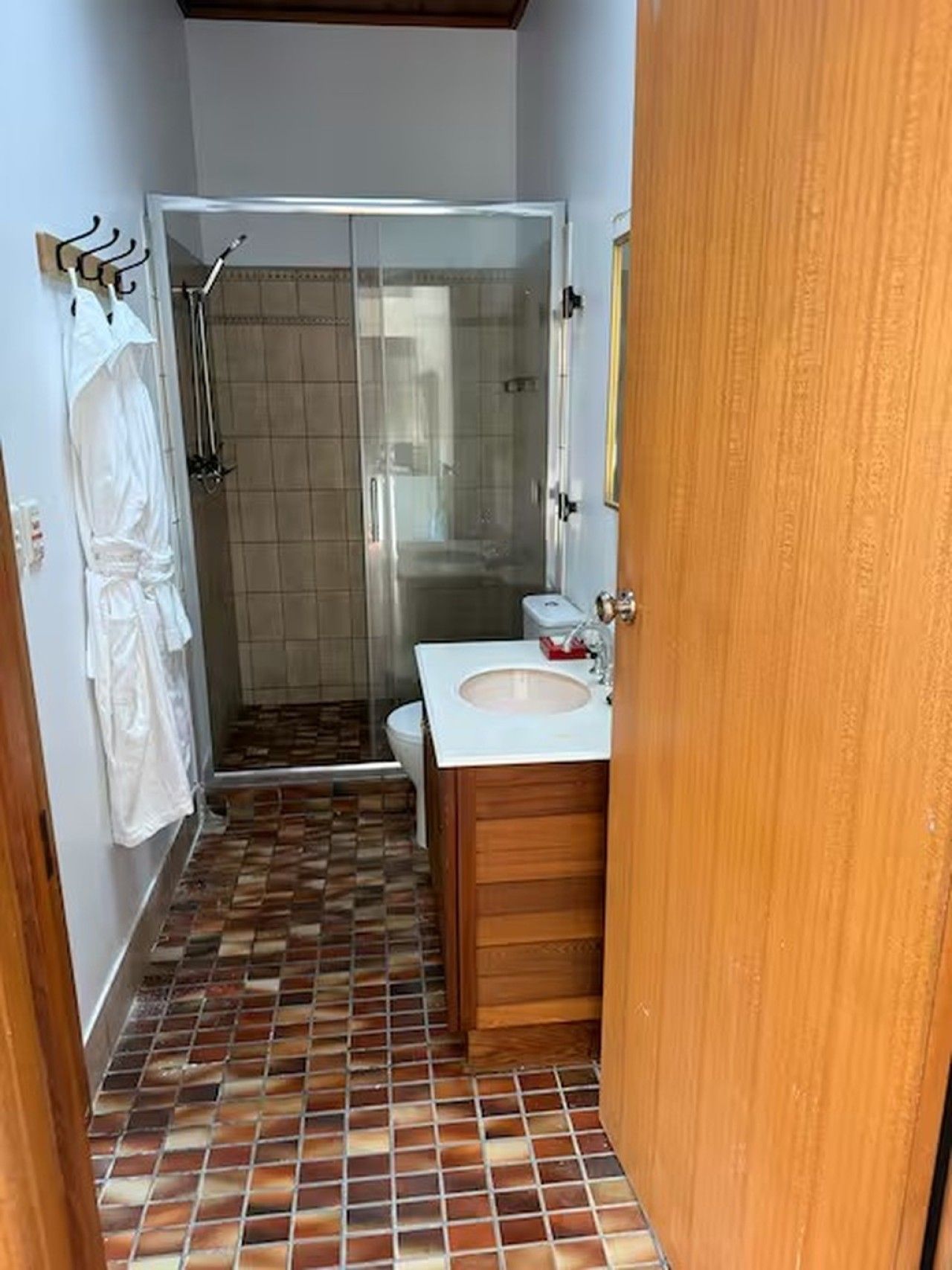 Ein Badezimmer mit Dusche, Toilette und Waschbecken.