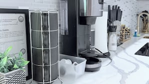 A modern kitchen with a coffee machine, a glass container, and a potted plant. - Bright apartment in Tavernier with Ac and kitchen, Tavernier key largo (Tavernier)