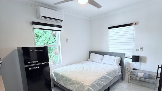 A modern bedroom with a bed, a desk, a chair, and a ceiling fan. - Bright apartment in Tavernier with Ac and kitchen, Tavernier key largo (Tavernier)
