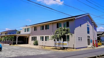 A two-story building with a sign for 'to.racck.base' indicating it is a guesthouse with amenities like a car rental, video production, and an adventure bar.