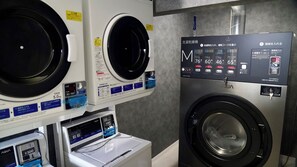 A laundry facility with multiple washing machines and a control panel.