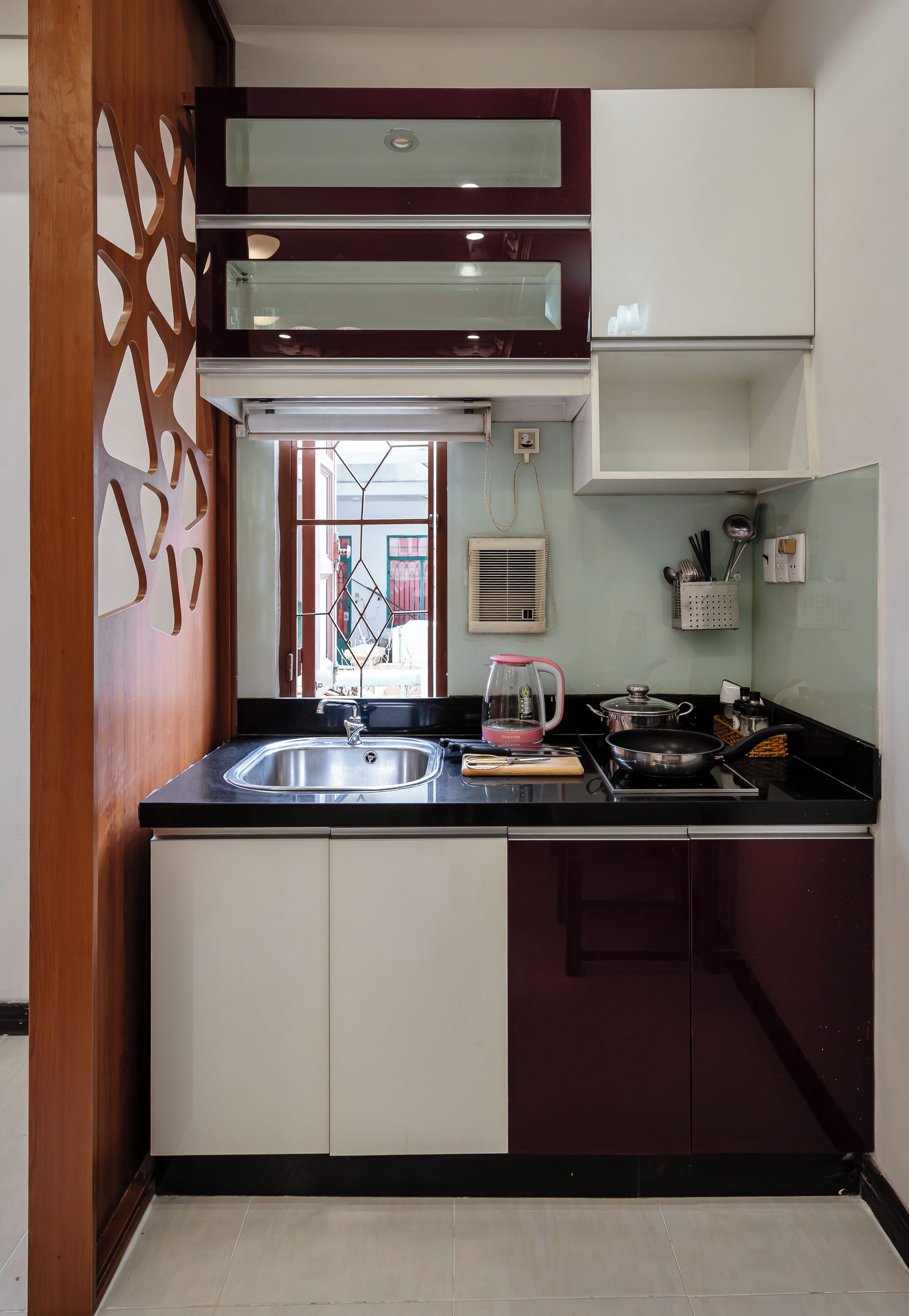 A modern kitchen with a double sink, a gas stove, and a coffee maker.