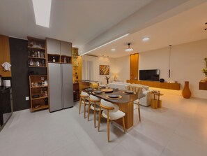 A modern kitchen with a central island, wooden cabinets, and a built-in refrigerator.
