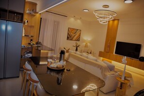 Uma sala de estar moderna com um sofá, uma mesa de centro e uma televisão.