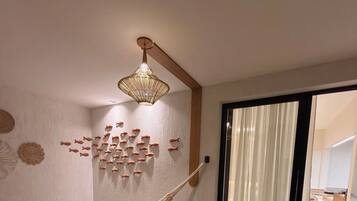 Une pièce avec un hamac, une décoration murale représentant des poissons, un luminaire suspendu et une porte-fenêtre coulissante.