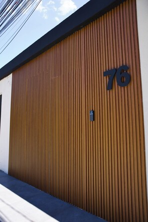 A modern building with a large wooden garage door marked with the number 76.