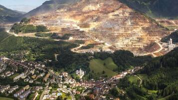 A town nestled in a valley with a large open-pit mine in the background.