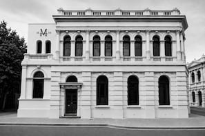A classical building with a symmetrical facade, large arched windows, and a prominent entrance. - The Mason (Fremantle)
