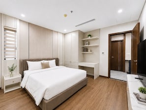 Een moderne slaapkamer met een bed, nachtkastjes, een garderobe en inbouwkasten.