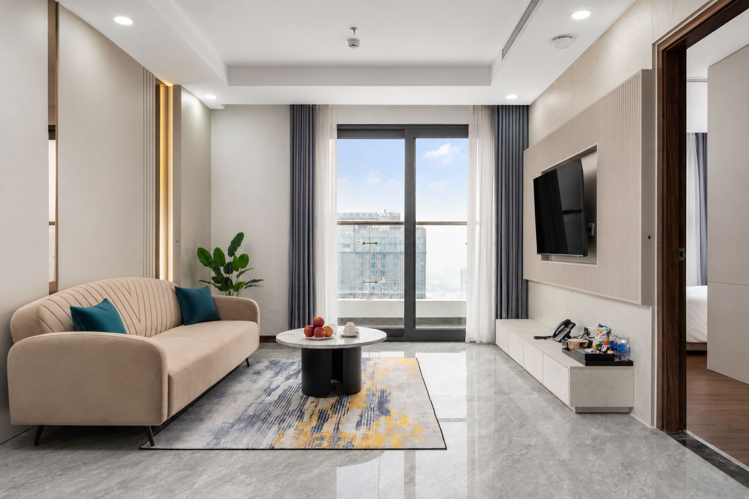 A modern living room with a sofa, a coffee table, and a TV mounted on the wall.