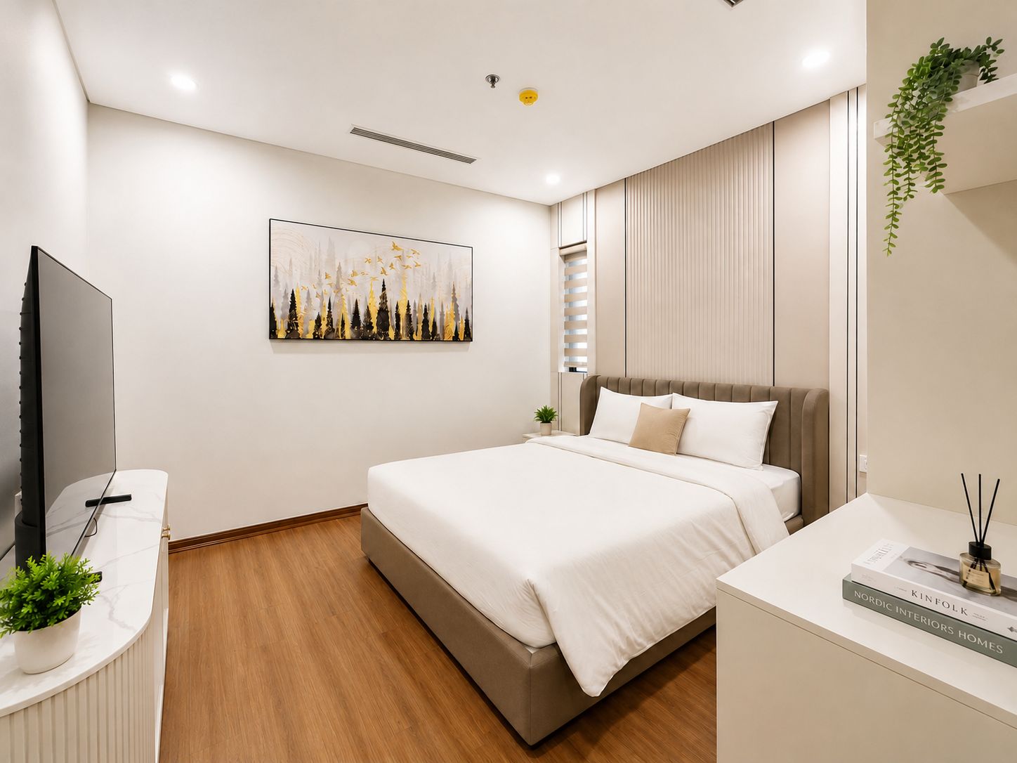 Un dormitorio moderno con cama, mesita de noche, televisor y una obra de arte.