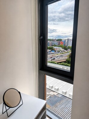 A room with a window overlooking a cityscape, a white desk, and a chair. - Modern Canal-Side 2BR - Balcony - Sleeps 8 (leeds)