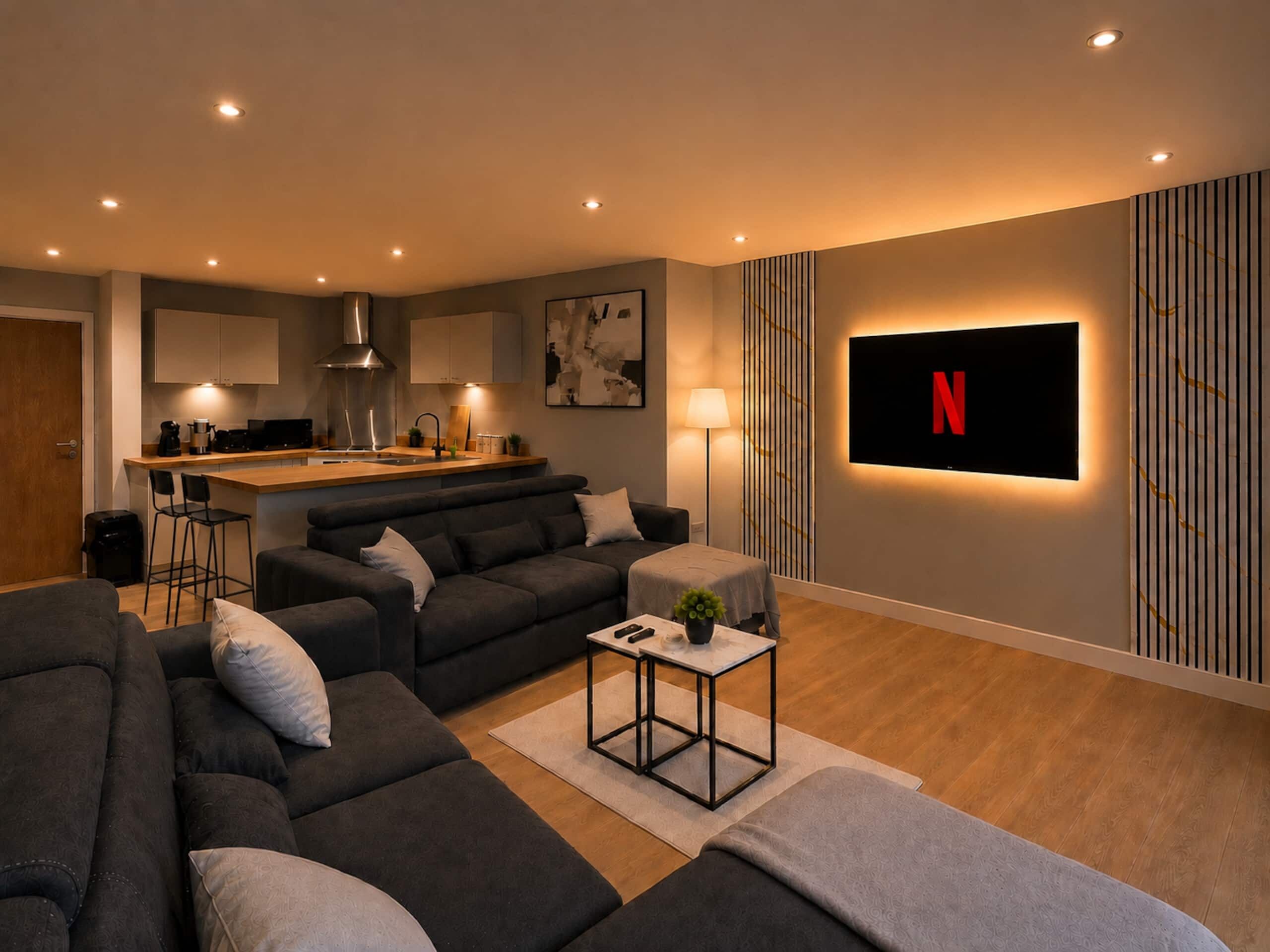 Ein modernes Wohnzimmer mit einer Couch, einem Couchtisch und einem an der Wand montierten Fernseher.