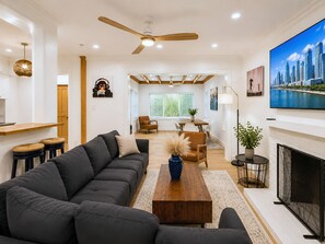 A modern living room with a sectional sofa, a wooden coffee table, and a fireplace. - Sunset Paradaise in Fort Lauderdale (Fort Lauderdale)