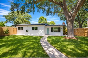 A single-story house with a front yard, a pathway leading to the entrance, and a large tree to the right. - Sunset Paradaise in Fort Lauderdale (Fort Lauderdale)