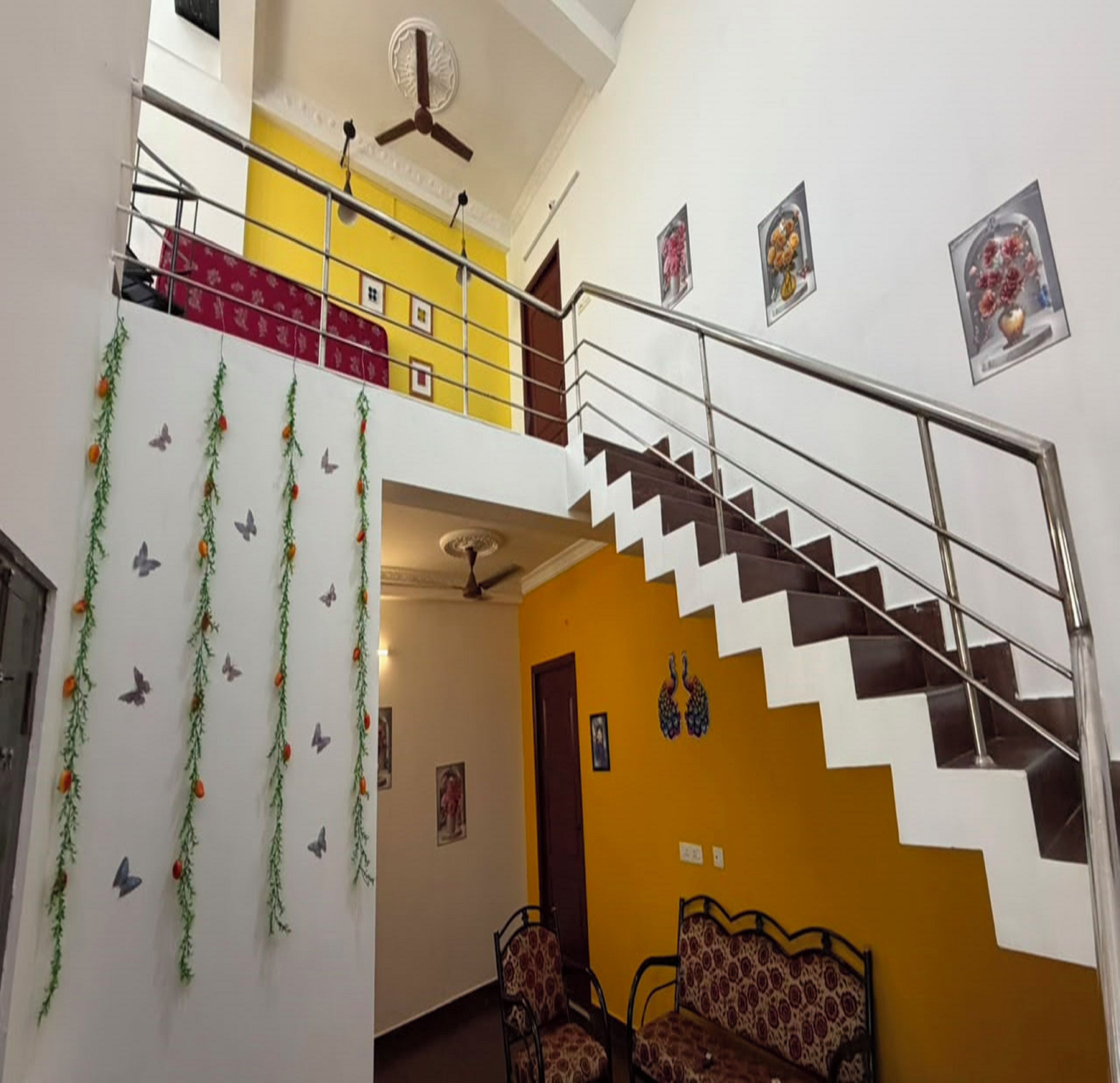 A multi-level interior with a staircase, decorative wall hangings, and patterned furniture.