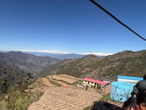 A mountainous landscape with terraced fields and a few buildings.