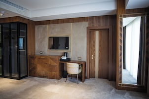 Een kamer met een bureau, stoel en televisie.