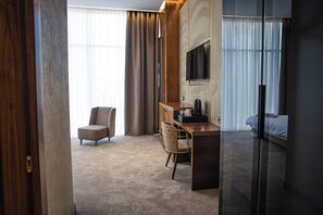 A hotel room with a bed, a desk, a chair, and a television. - The Arte Hotel (Yerevan)