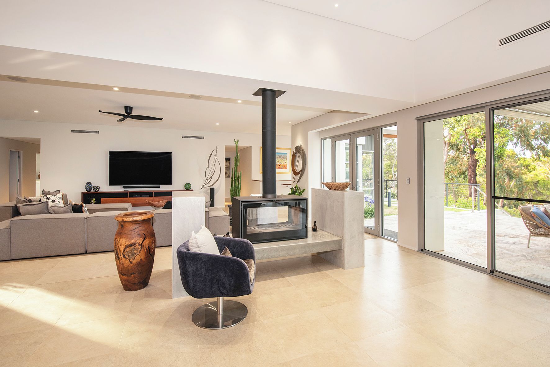 A modern living room with a fireplace, a sofa, a television, and a large window.