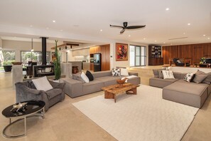 A spacious living area with a large sectional sofa, a coffee table, and a television. - Amira Vista - Views of Eagle Bay (Eagle Bay)