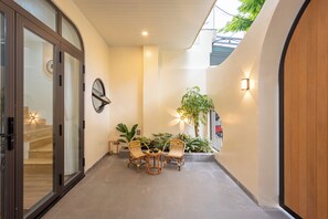 A corridor with a seating area, a staircase, and a door with glass panels. - Nimi Han River: 3BR-4 Beds | Private Pool & Beach (Đà Nẵng)