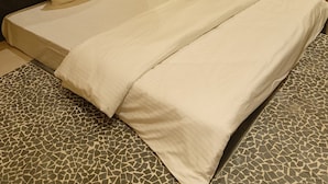 Una habitación de hotel con una cama, un espejo y un aire acondicionado instalado en la pared.