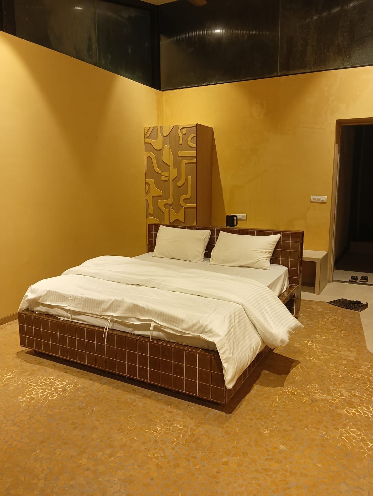 Ein Hotelzimmer mit einem großen Bett, einem Nachttisch und einem Spiegel.