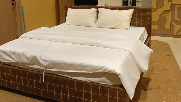 Un dormitorio con cama, armario y puerta al baño.