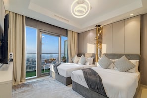 A modern hotel room with two beds, a large window with a city view, a ceiling light, and a wall-mounted TV. - Gogoto12 Luxury Skyline 2BR with Burj Khalifa view (Dubai)
