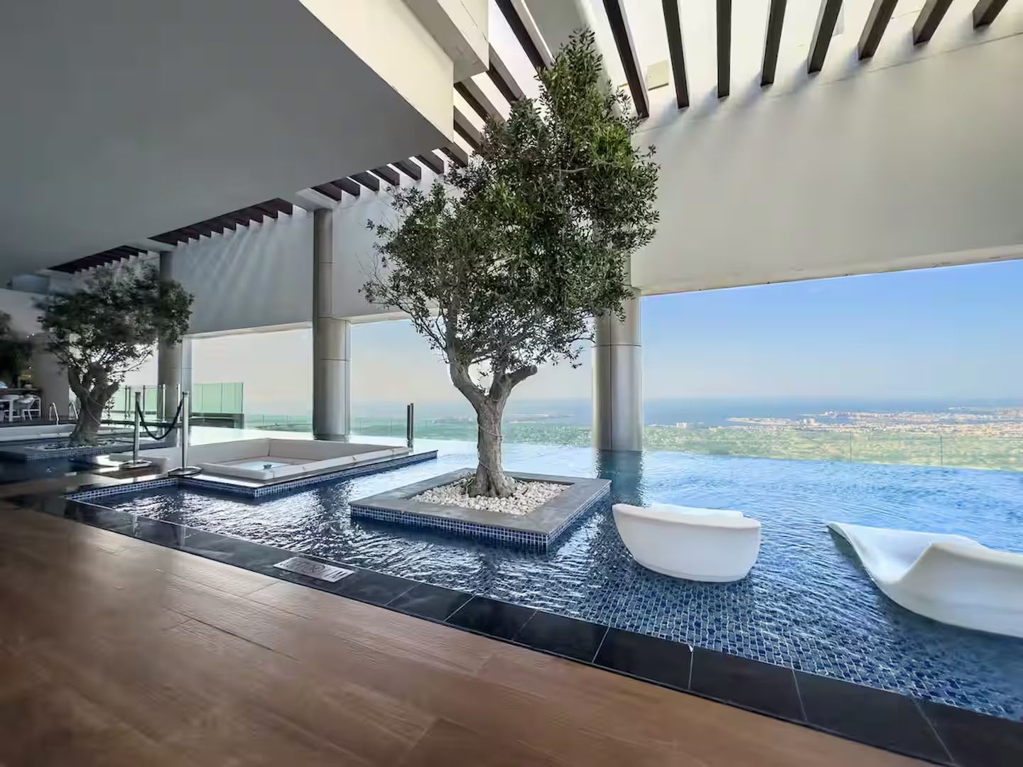 Una piscina infinita moderna en el interior, con vistas a la ciudad.