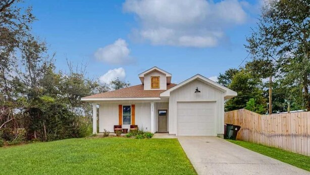 A single-story house with a front porch, a garage, and a well-maintained lawn. - Coastal Getaway in Perdido Key (Pensacola)