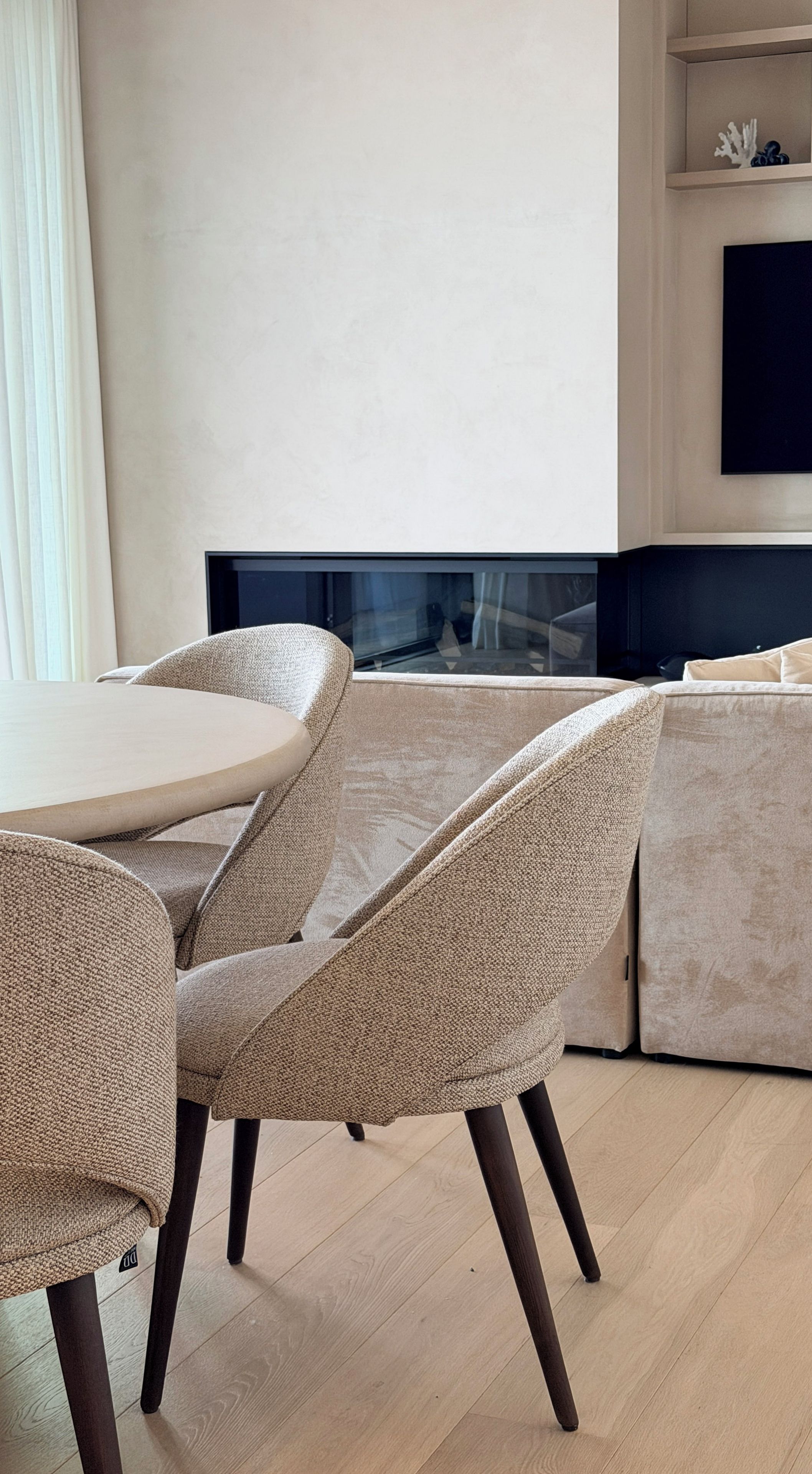 Un espace repas moderne avec une table ronde et quatre chaises rembourrées.