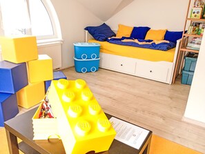 A child's playroom with a bed, storage bins, and a table with a toy structure. - Ubytkostka by Interhome (Rokytnice nad Jizerou)