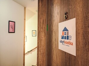 A wooden door with a number '6' and a sign with a house and dice icon, indicating a hotel or lodging establishment. - Ubytkostka by Interhome (Rokytnice nad Jizerou)
