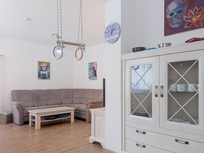 A living room with a sofa, a coffee table, a cabinet with glass doors, and wall art. - Apartment V&D 0 by Interhome (Rokytnice nad Jizerou)