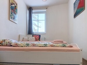 A bedroom with a bed, pillows, a window, and artwork on the walls. - Apartment V&D 0 by Interhome (Rokytnice nad Jizerou)