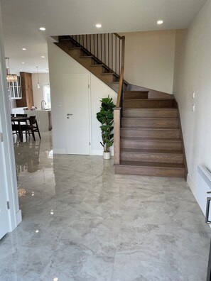 Ein modernes Interieur mit einer Holztreppe, einem Essbereich und einer Küche.