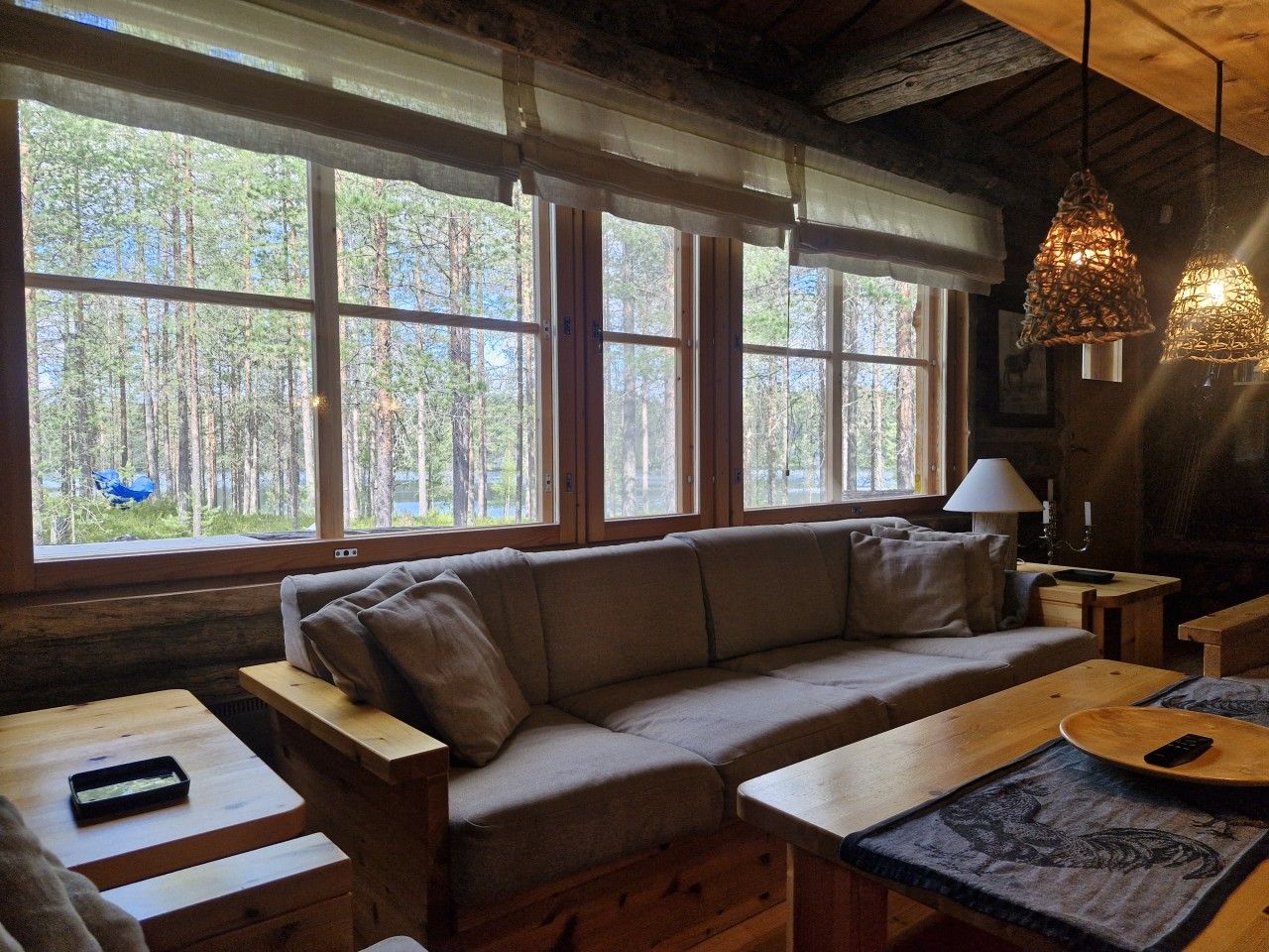 L'intérieur d'un chalet confortable, avec un canapé, une table et une lampe.
