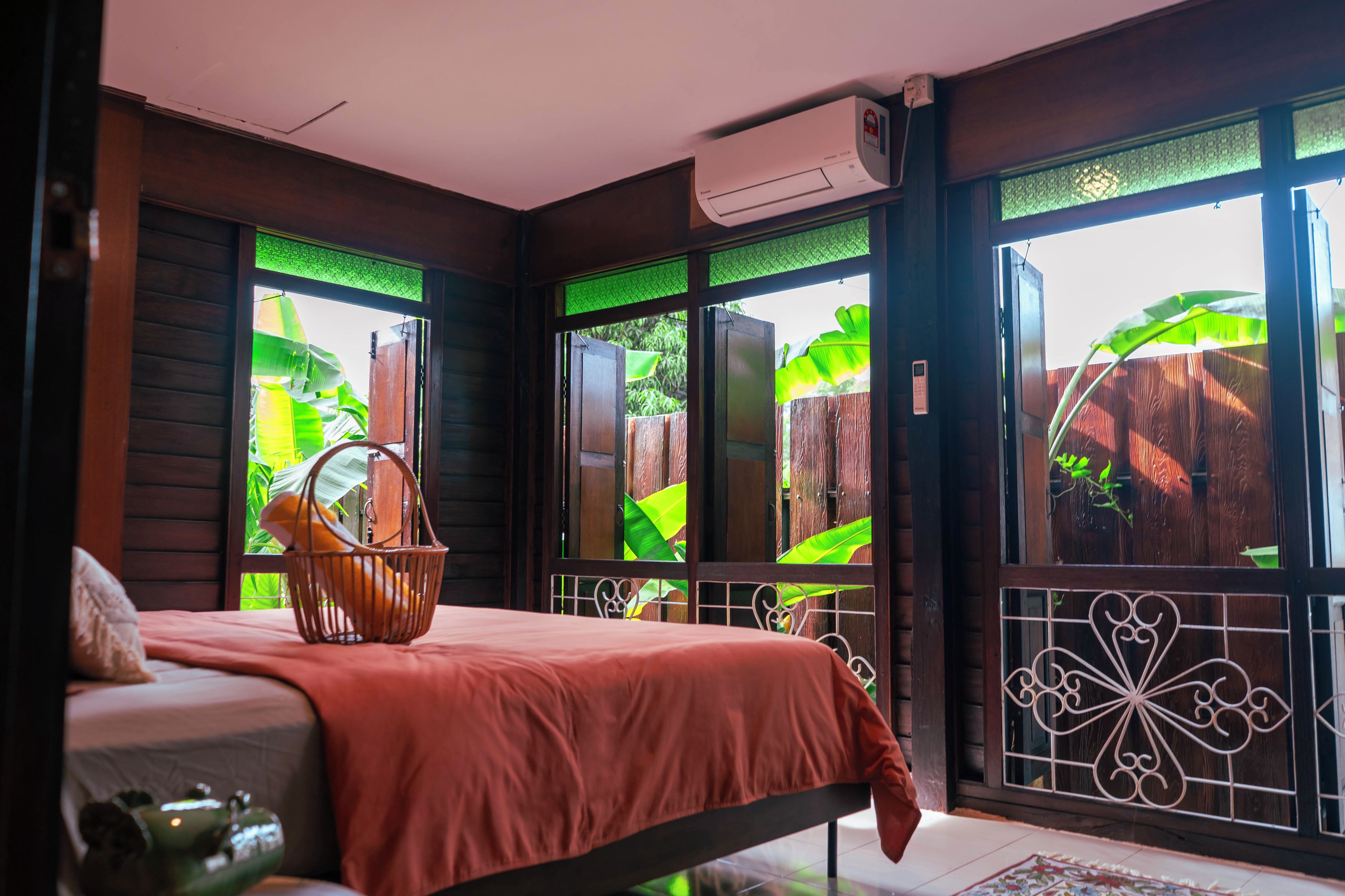 Una habitación con cama, ventana con vistas a zonas verdes y aire acondicionado.