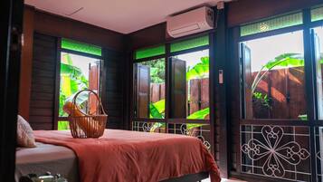 Una habitación con cama, ventana con vistas a zonas verdes y aire acondicionado.