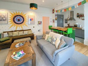 Ein Wohnzimmer mit einer Couch, einem Couchtisch und einem Essbereich mit Tisch und Stühlen.