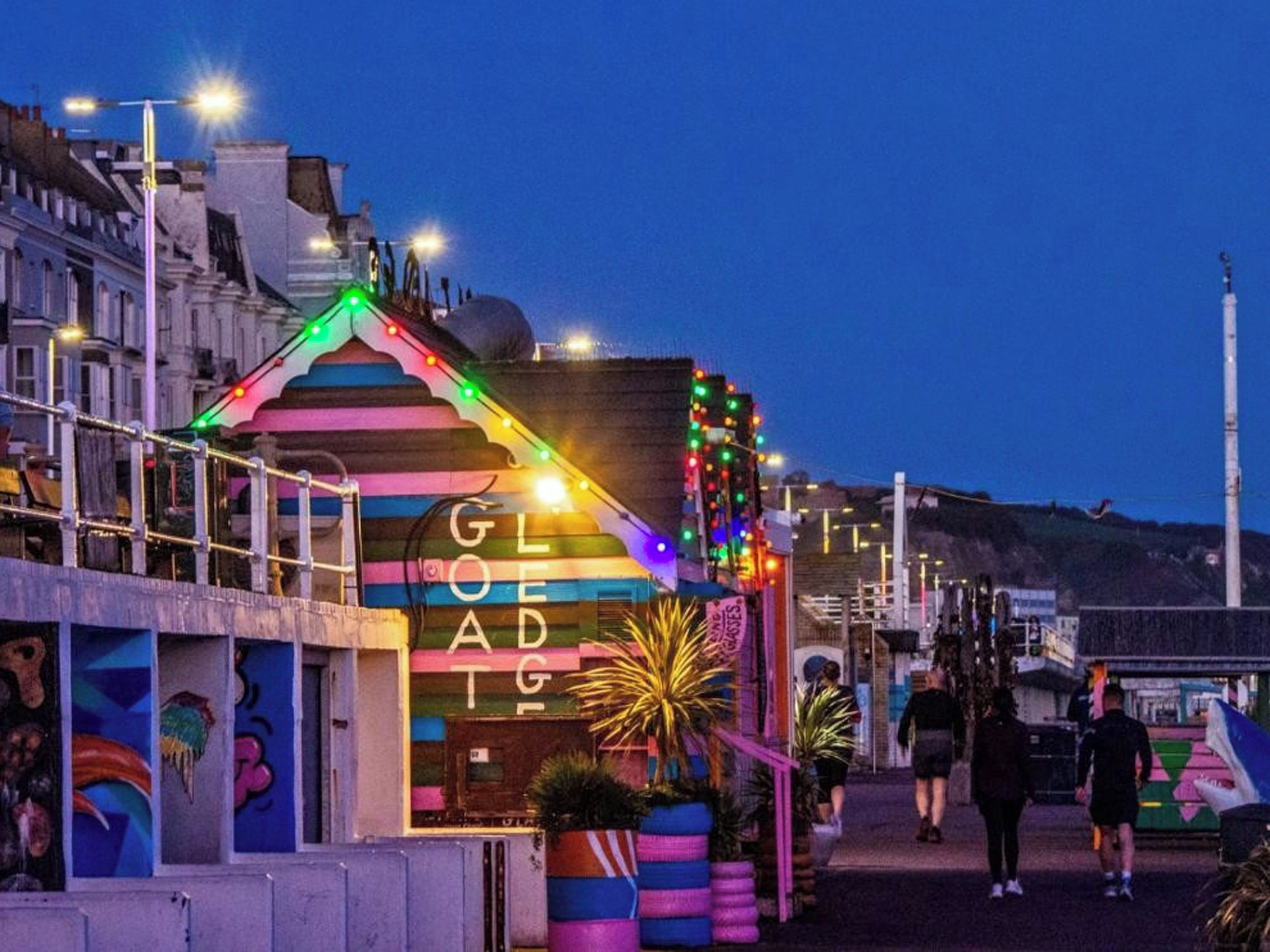 Um edifício colorido com uma placa que diz 'GOED' e uma fileira de luzes.